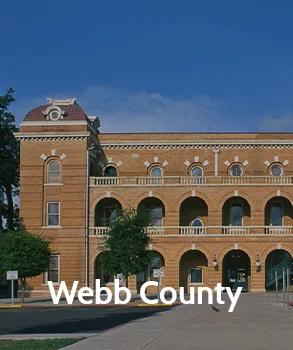Webb County courthouse with historic architecture, featuring arched windows and a red-tiled roof, representing Webb County’s legal and governmental heritage.